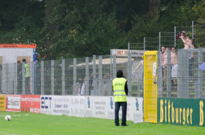 Die Flensburger Fans feiern den starken Regen lautstark und halb nackt. Foto: Tim Eckhardt.