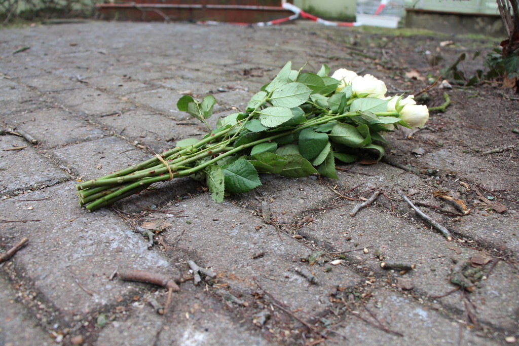 Vor dem Haus liegen Blumen von Trauernden. Foto: Till Heinsohn