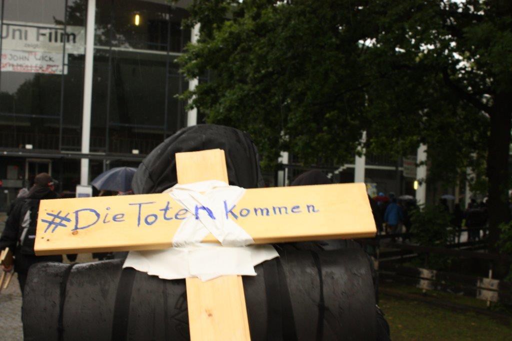 Ein Teilnehmer trägt ein Kreuz mit dem Slogan der Aktion. Foto: AStA der Uni Hamburg.