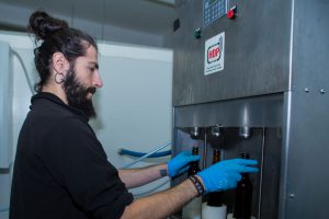 Hygiene groß geschrieben: Mit blauen Plastikhandschuhen bedient José den Füller, der pro Gang vier Flaschen mit Bier befüllt. Foto: Holger Vogel