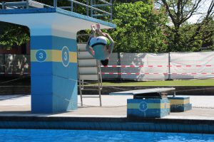 ... übt schon mal fleißig Saltos vom einer. Er freut sich über die Erfrischung im kühlen Freibad-Wasser. Foto: Max Gilbert