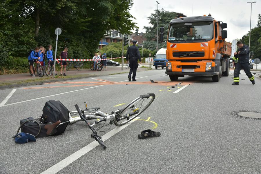 Das kaputte Fahrrad liegt vor dem orangenen LKW. Foto: Jonas Walzberg