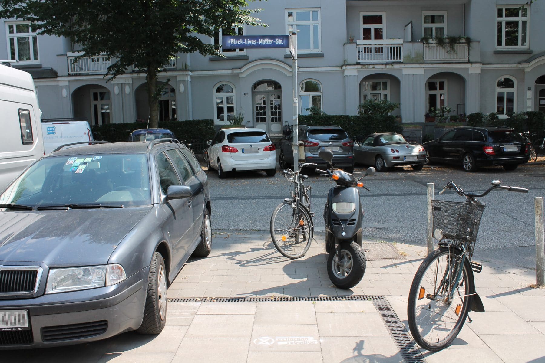 Auf dem Bürgersteig vor dem Straßenschild ist das Logo von Extinction Rebellion zu sehen. Foto: Marianne Bruhns
