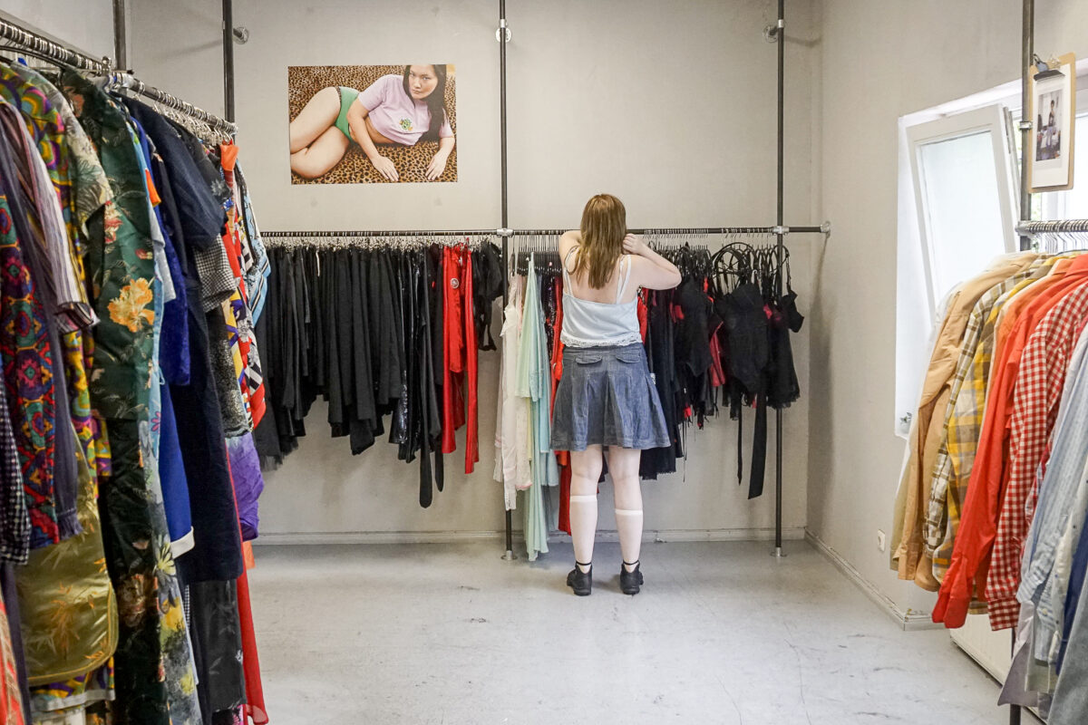 Zwischen den Kleiderstangen bei „Vintage Revivals“ sucht eine Kundin nach besonderen Secondhand-Schätzen. Foto: Teresa Runge